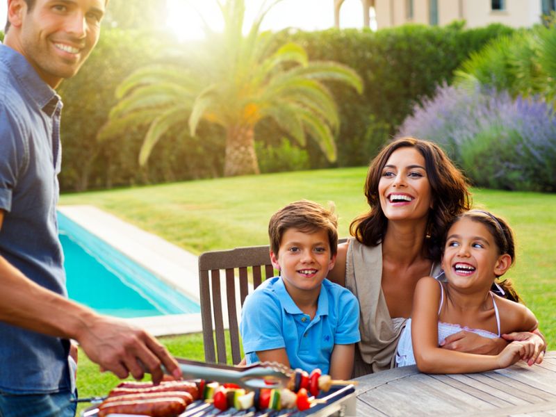 Famiglia che si gode un BBQ in giardino protetta dai servizi di disinfestazione Alpha Range
